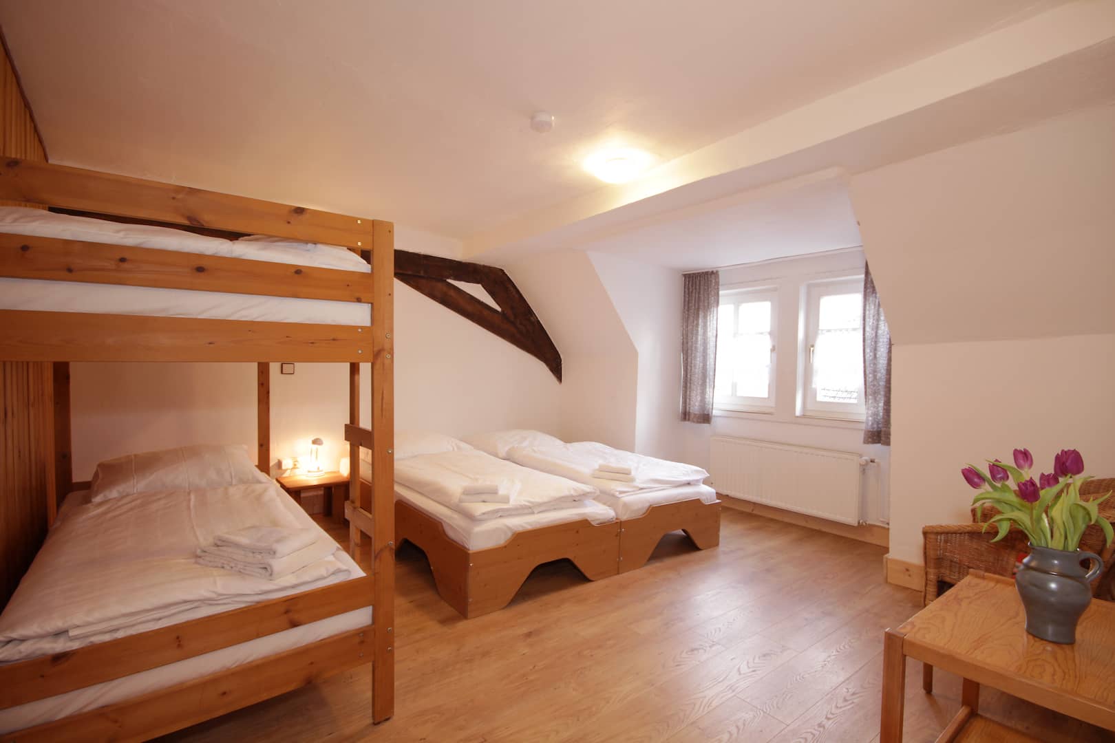 4-Bett Zimmer mit 2 Einzel- und einem Etagenbett in Apartment 61 der FeWo Amsel; Blick zu Fenster